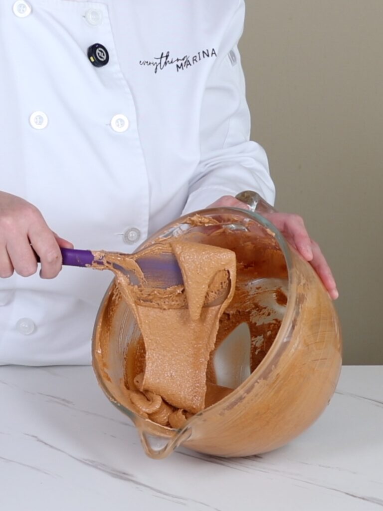 Brown macaronage flows from the spatula.