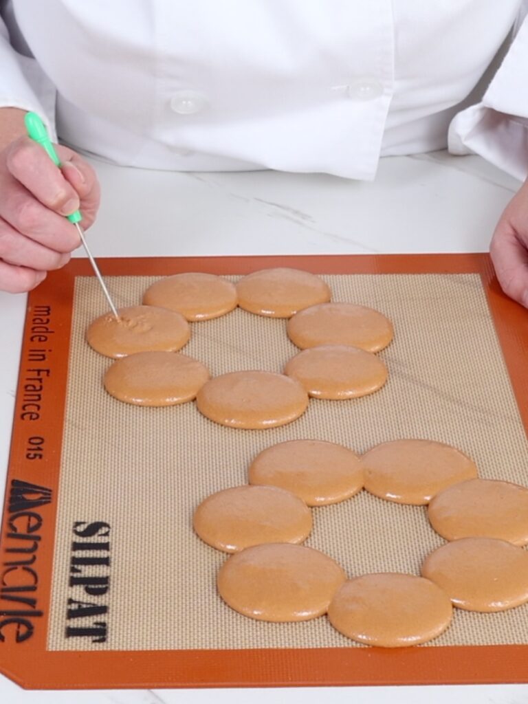 The hand is popping bubbles with a toothpick.