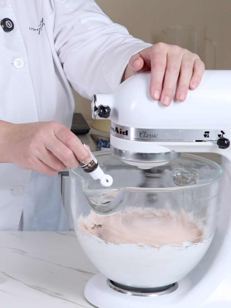 Adding gel food coloring to meringue. 