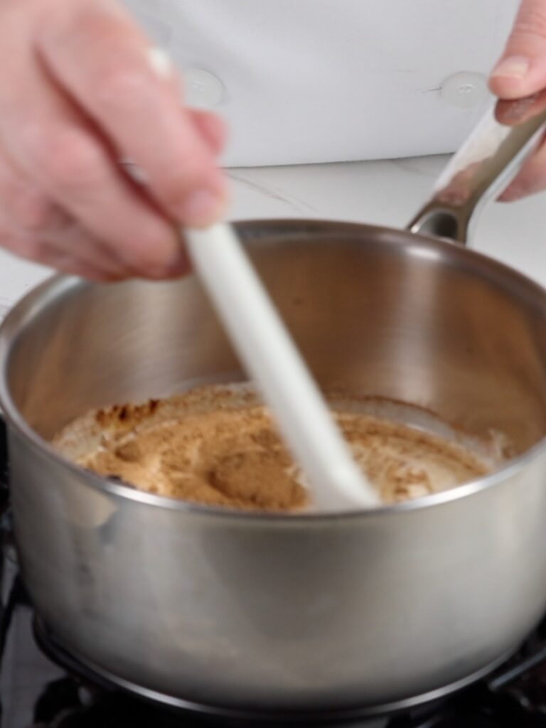 Saucepan with heavy cream and spices. 