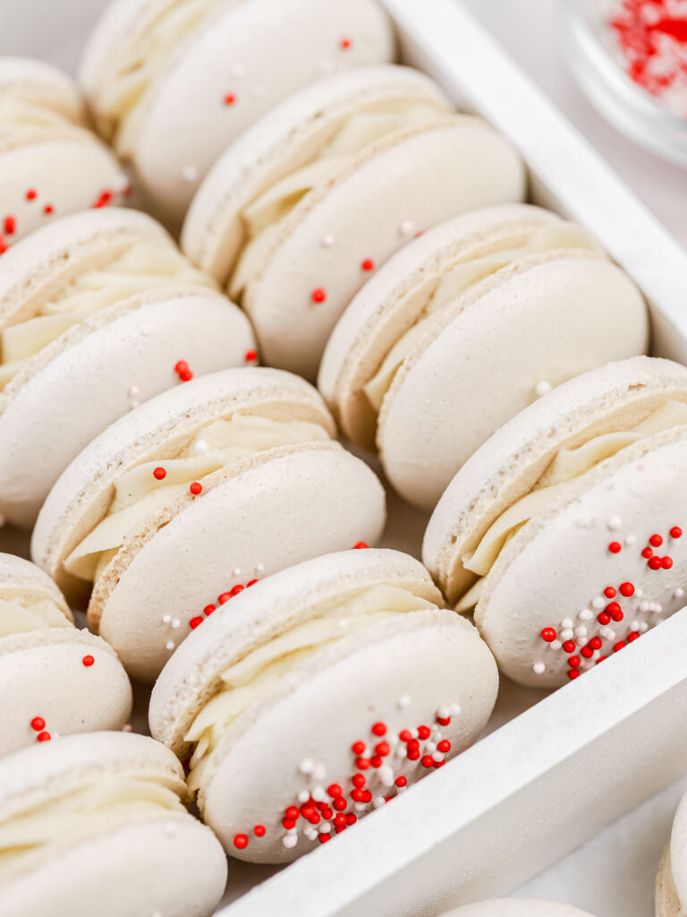 White macarons with sprinkles in the box.