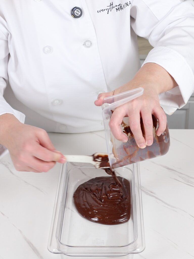 Pouring peppermint mocha ganache into a flat container. 