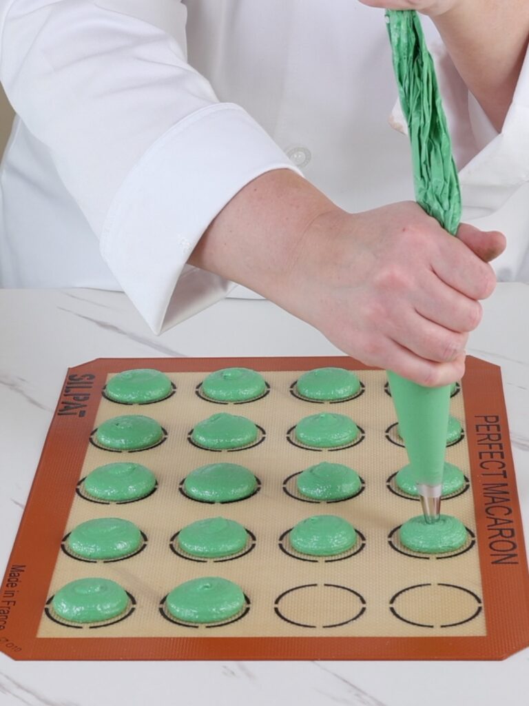 Piping green macarons. 