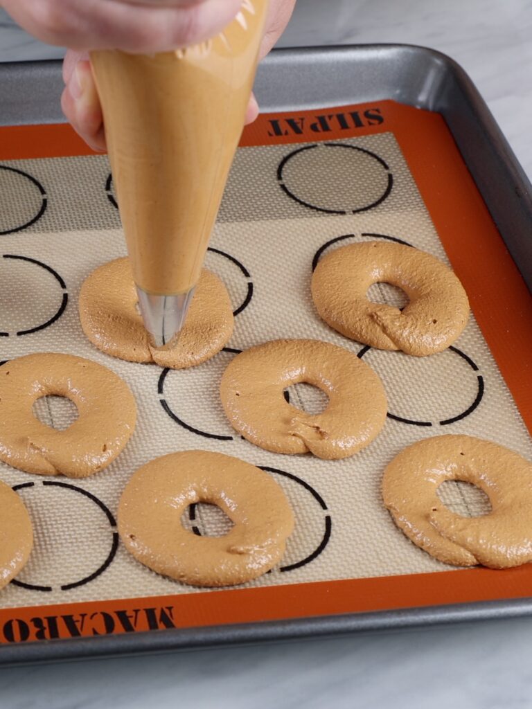Pipping donut macarons. 