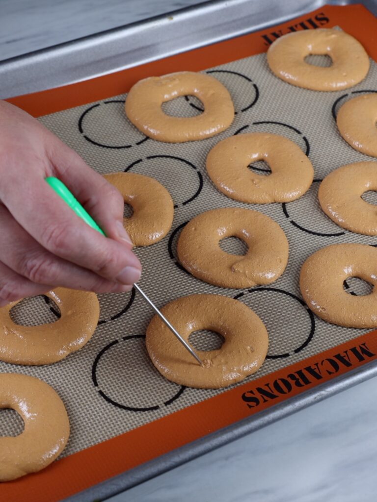 Popping air bubbles in the macarons. 