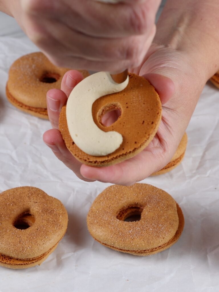 Piping filling on the macaron shell. 