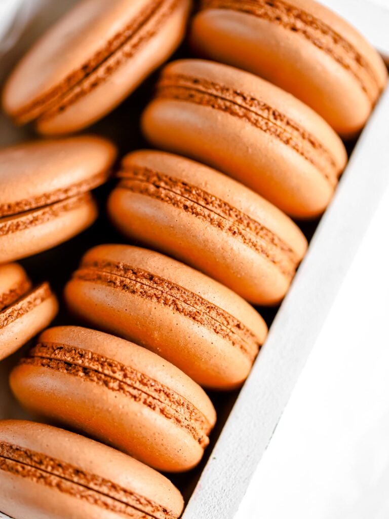 Brown macaron shells in the box. 