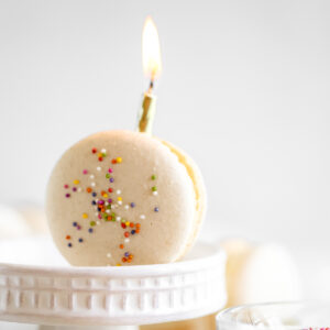 Birthday cake macaron with the candle on the table.