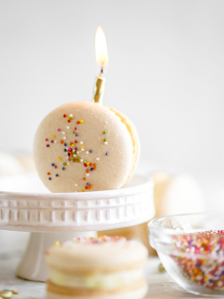 Birthday cake macaron with the candle on the table. 