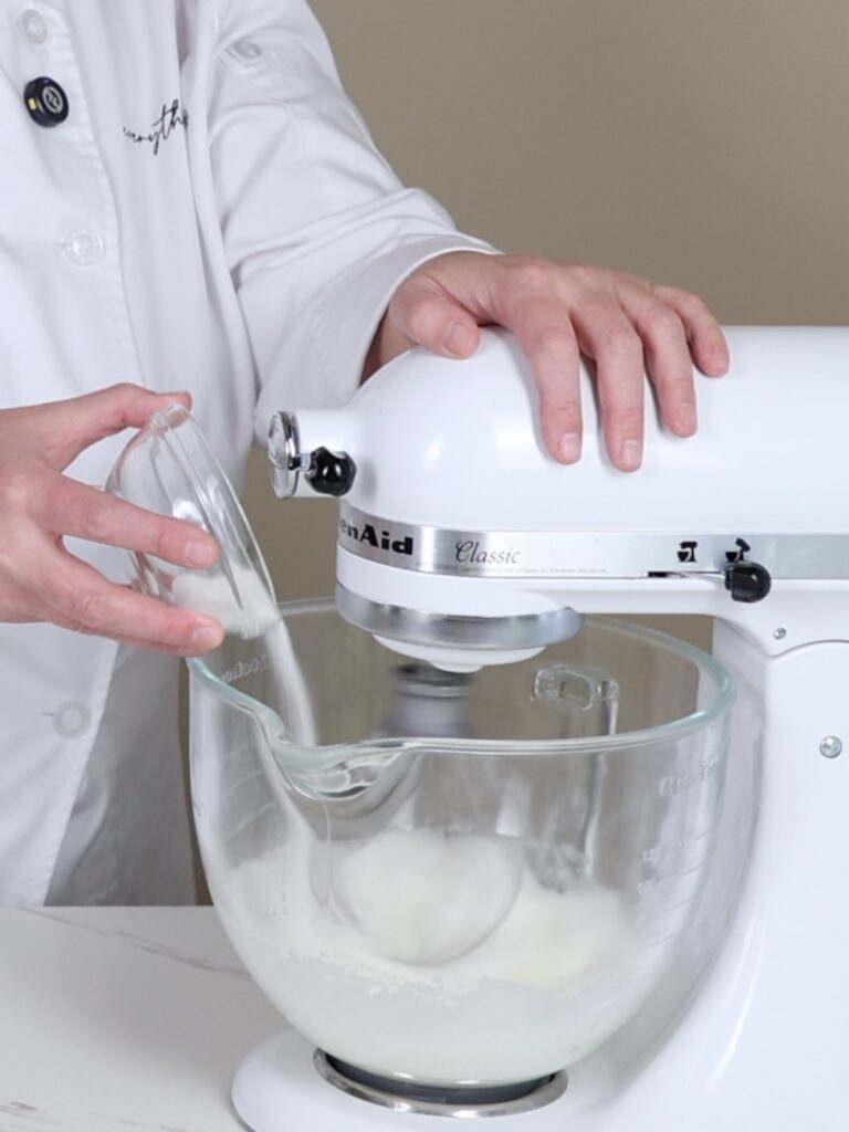 Pouring sugar into the mixing bowl. 