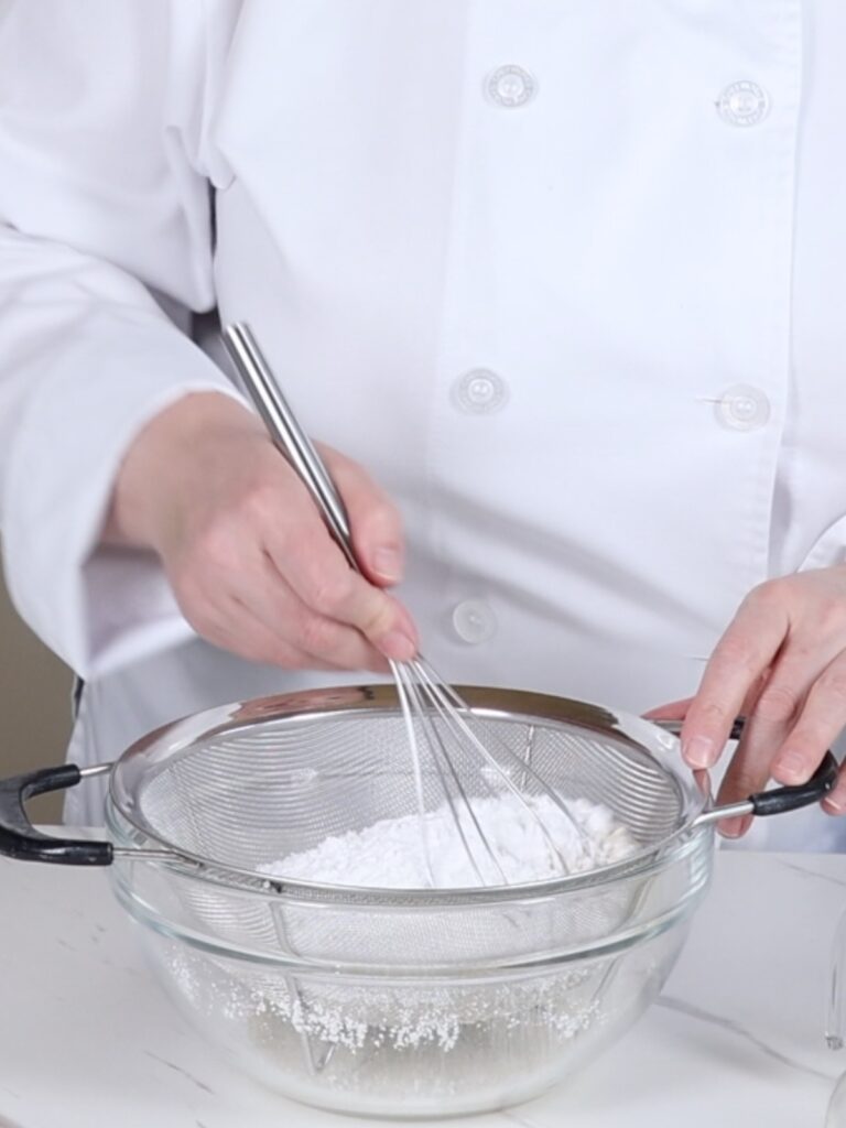 Sifting dry ingredients in the mixing bowl. 