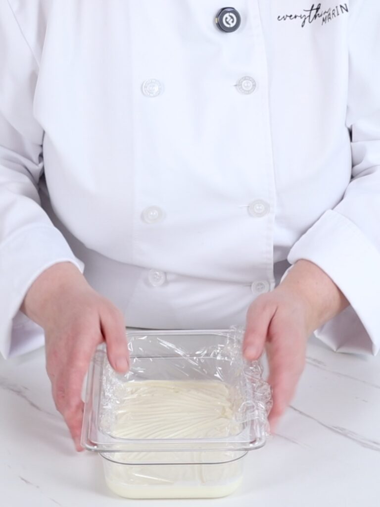 Covered with a plastic flat container with the ganache. 