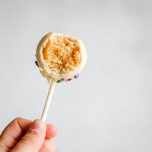 A hand is holding a cake pop.