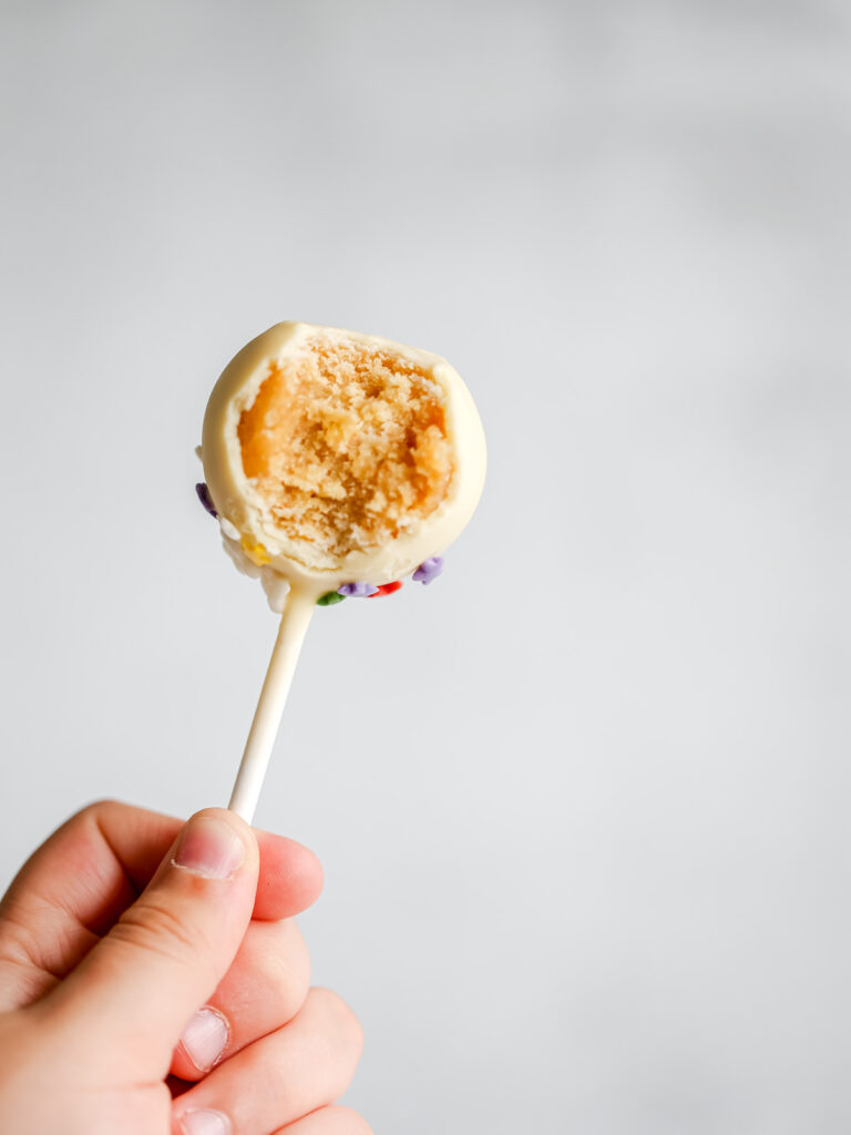 A hand is holding a cake pop. 