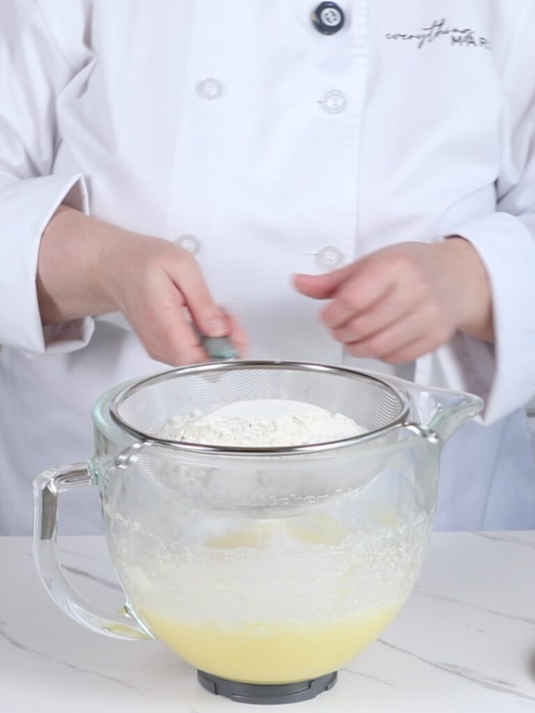 Sifting dry ingredients into a mixing bowl. 