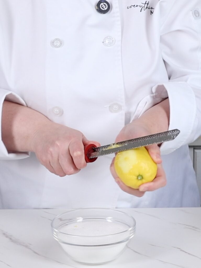 Adding lemon zest to sugar. 