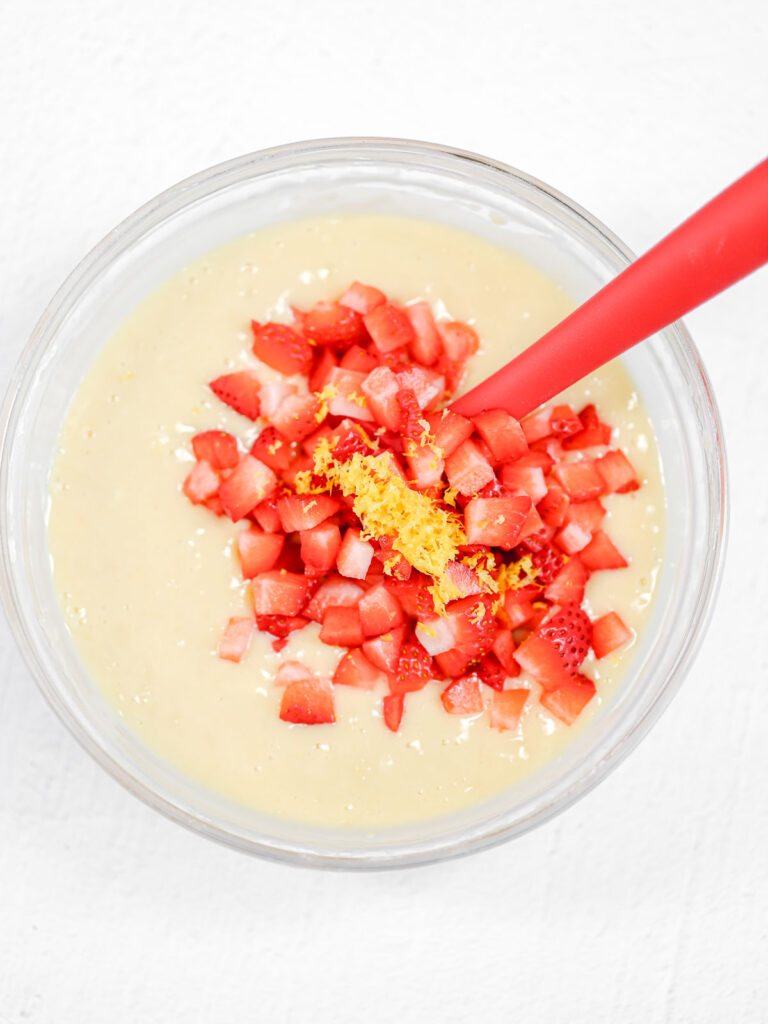 Muffin batter with strawberries in the bowl.