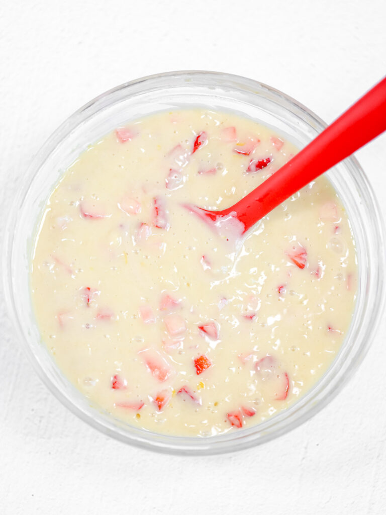 Muffin batter with strawberries in the bowl.