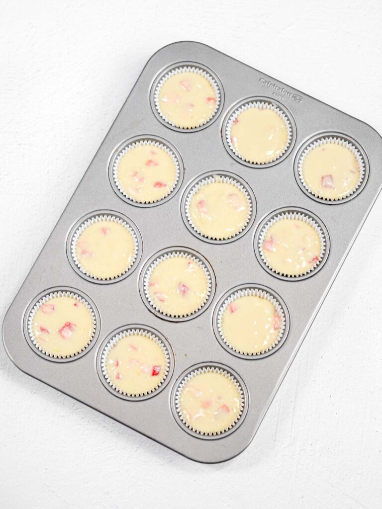 Muffin batter in the baking tray.