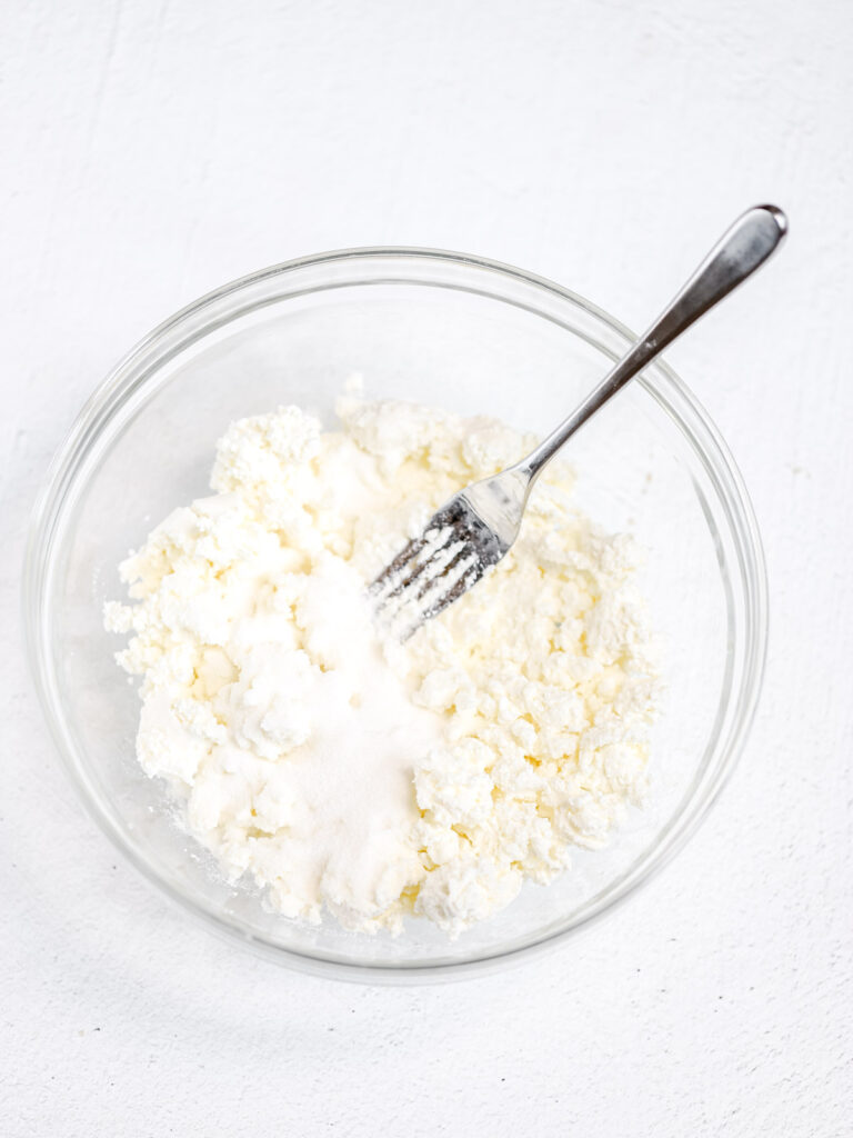 Farmer cheese and sugar in the mixing bowl. 