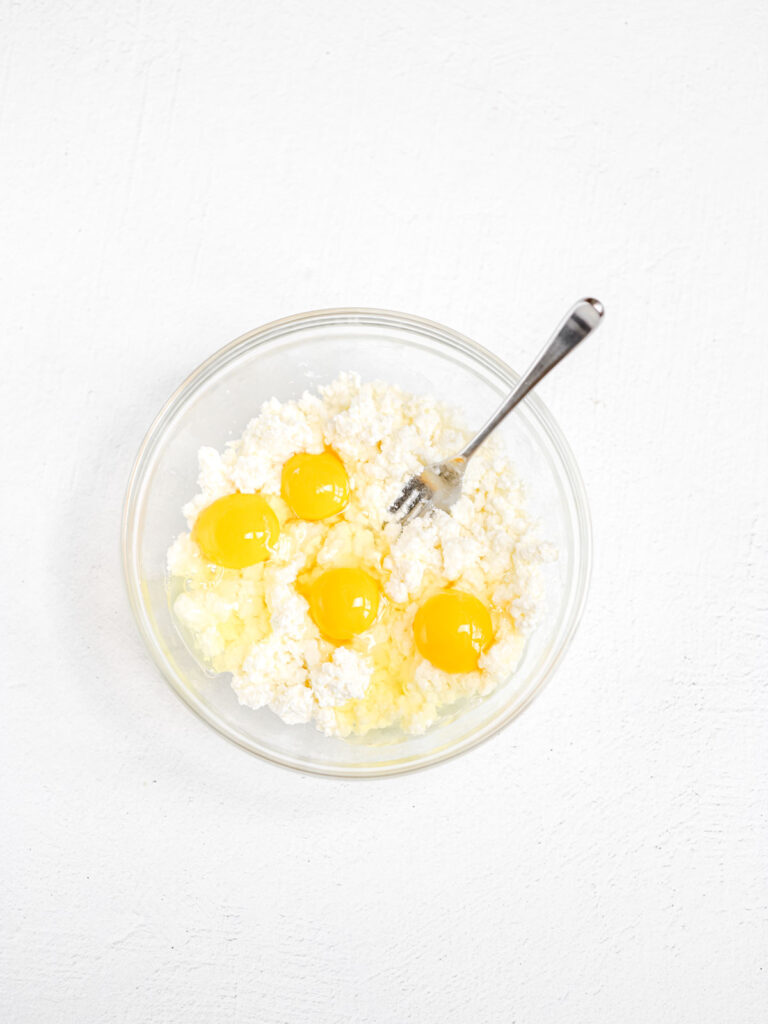 Eggs and farmer cheese in the mixing bowl. 