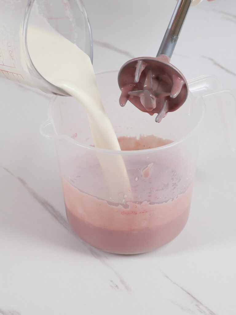 Adding heavy cream to a cup.