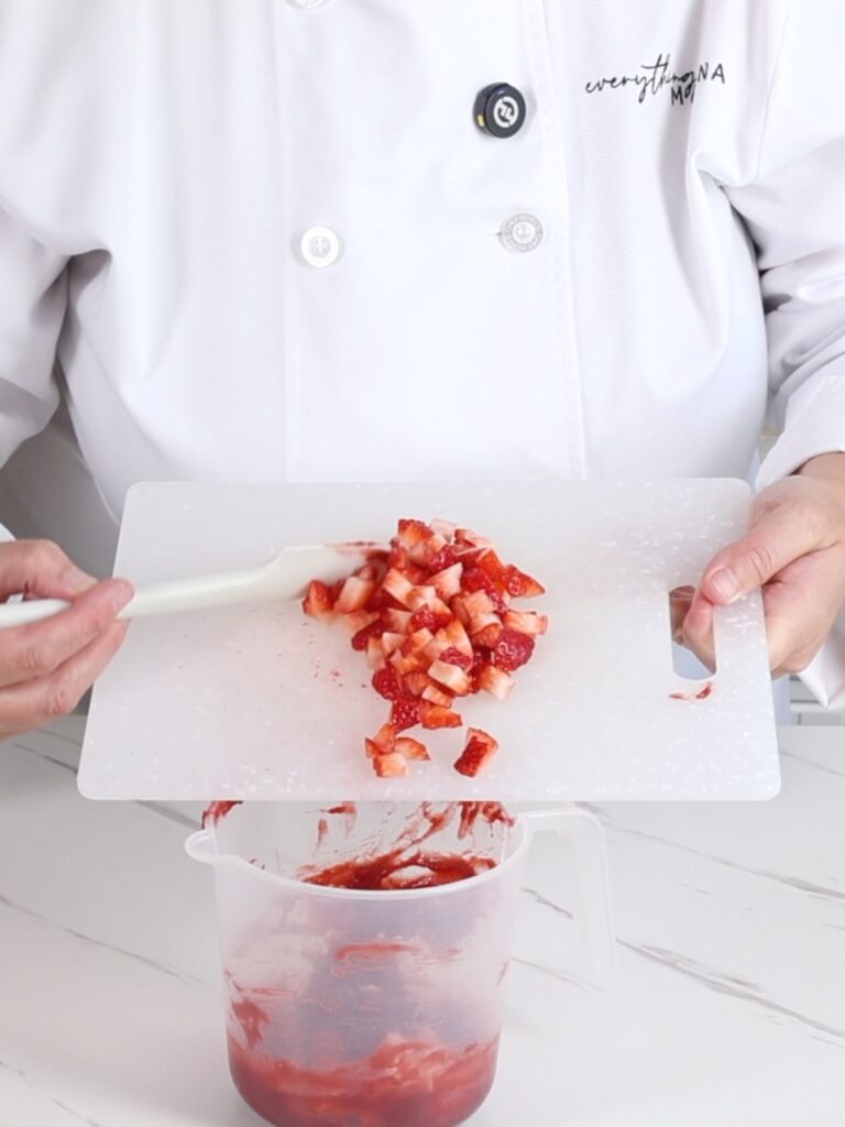 Adding fresh strawberries to confit.