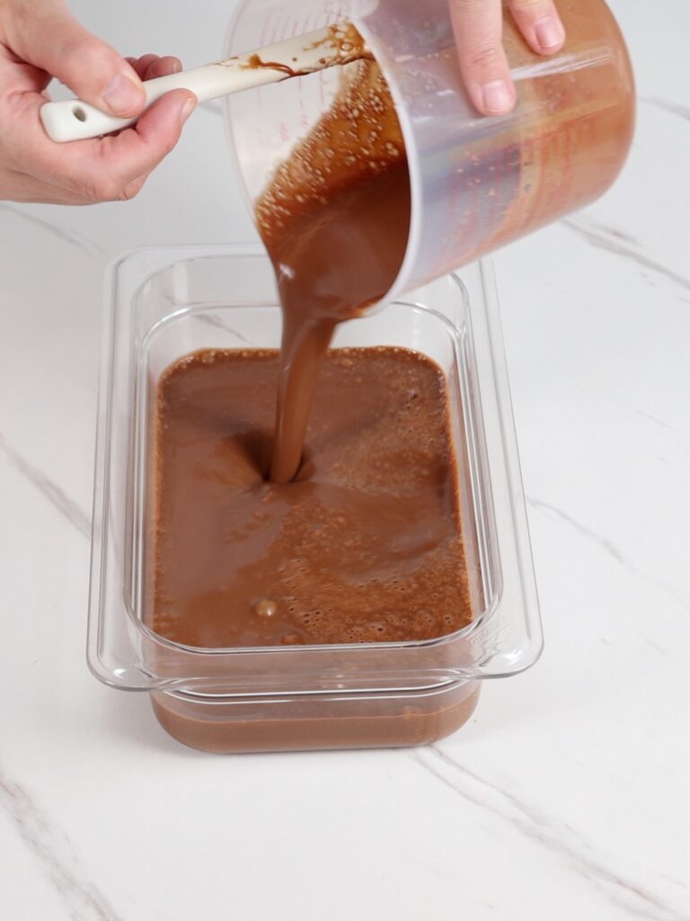 Pouring ganache into a flat container.