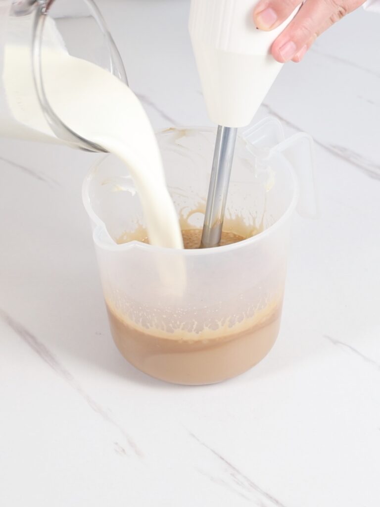 Pouring heavy cream into a cup. 