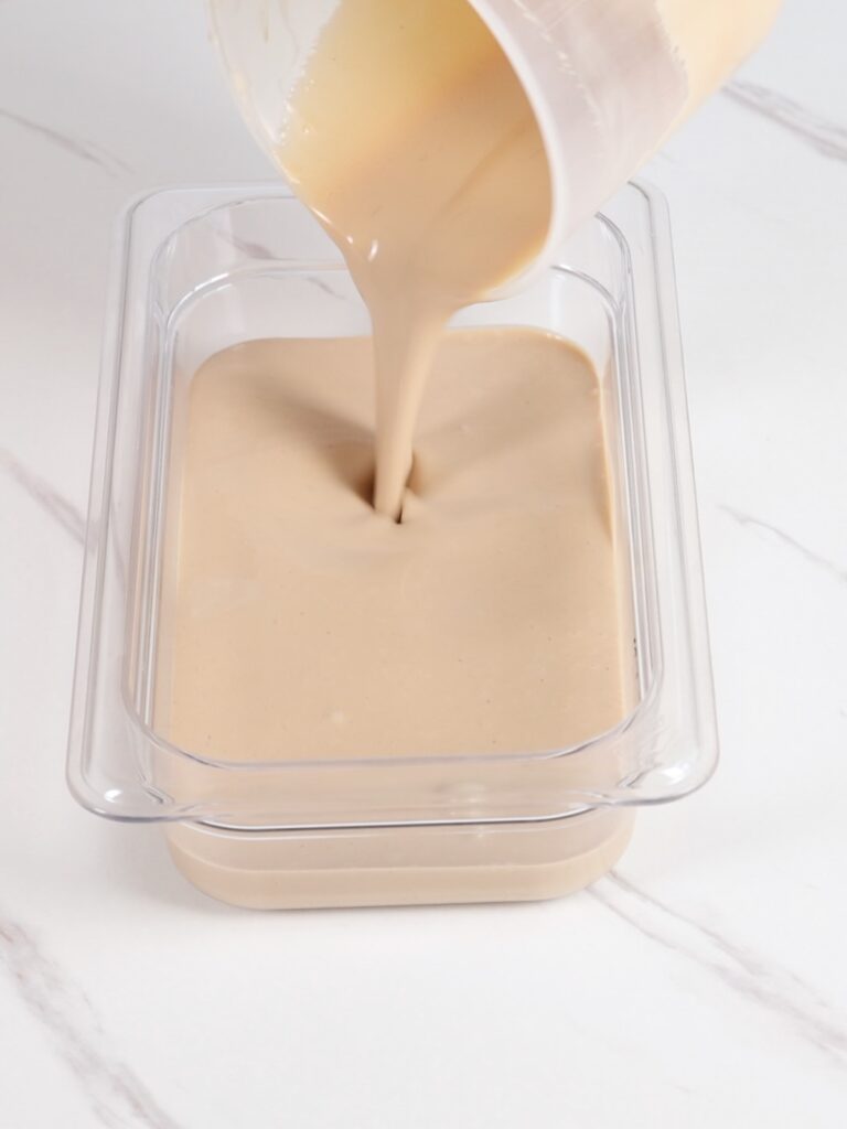 Pouring coffee ganache into a flat container. 