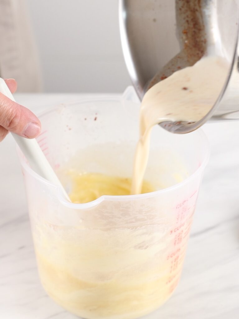 Pouring heavy cream into a cup.