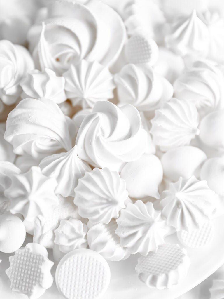 White meringue cookies on the plate.