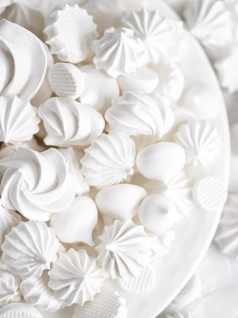 White meringue cookies on the plate.