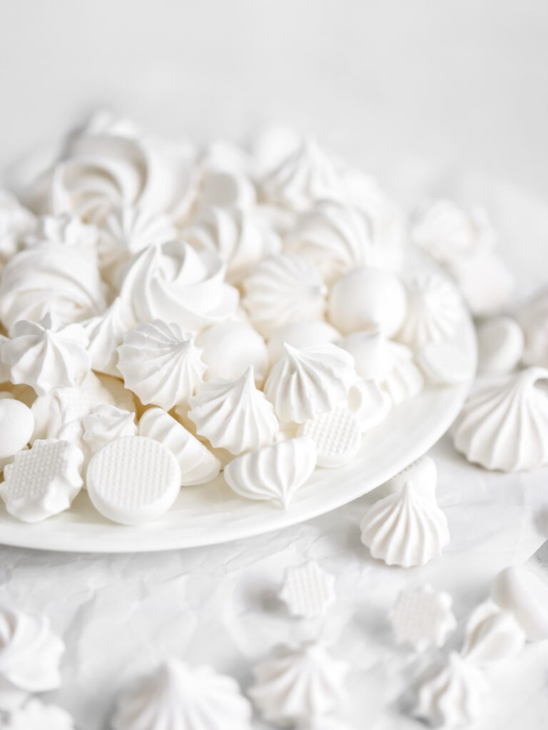 White meringue cookies on the plate.