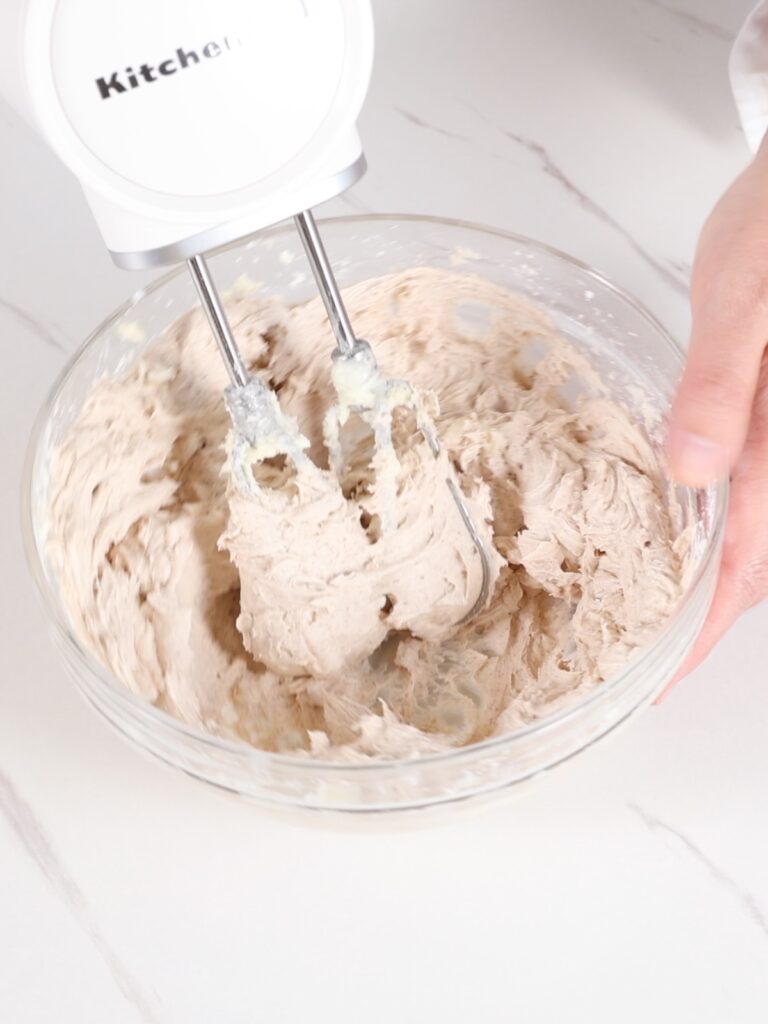 Whipping pumpkin spice buttercream in the mixing bowl. 