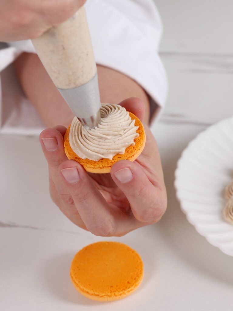 Filling macarons with pumpkin spice buttercream. 